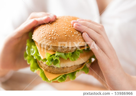 close up of woman holding hamburger 53986966