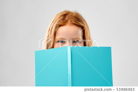 smiling red haired girl reading book smiling red haired girl reading book 53986983