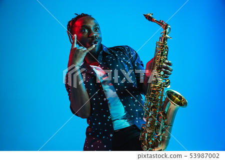 Young african-american jazz musician playing the saxophone Young african-american jazz musician playing the saxophone 53987002