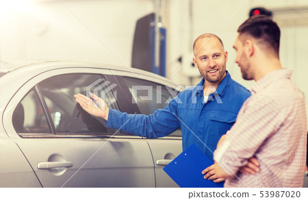 auto mechanic with clipboard and man at car shop 53987020