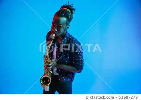 Young african-american jazz musician playing the saxophone Young african-american jazz musician playing the saxophone 53987279