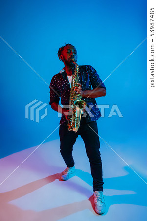 Young african-american jazz musician playing the saxophone Young african-american jazz musician playing the saxophone 53987485
