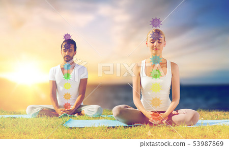 couple doing yoga in lotus pose with seven chakras 53987869