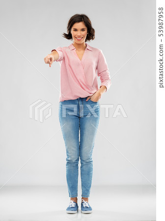 young woman in shirt and jeans pointing to you 53987958