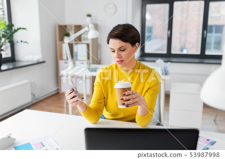woman with coffee using smartphone at office woman with coffee using smartphone at office 53987998