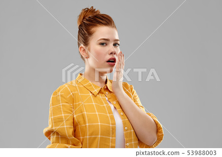 red haired teenage girl covering mouth by hands red haired teenage girl covering mouth by hands 53988003
