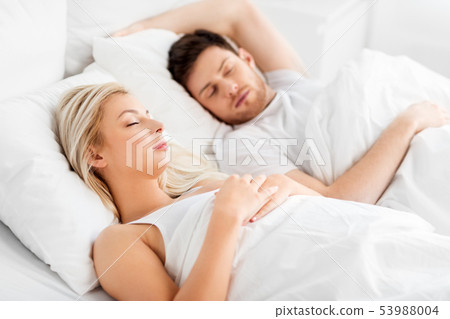 happy couple sleeping in bed at home happy couple sleeping in bed at home 53988004