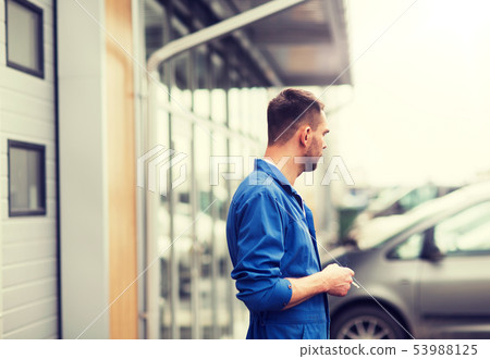auto mechanic smoking cigarette at car workshop 53988125
