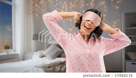 happy young woman in pajama and eye sleeping mask happy young woman in pajama and eye sleeping mask 53988216