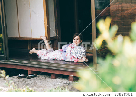 A woman in a yukata that cools on the veranda 53988791