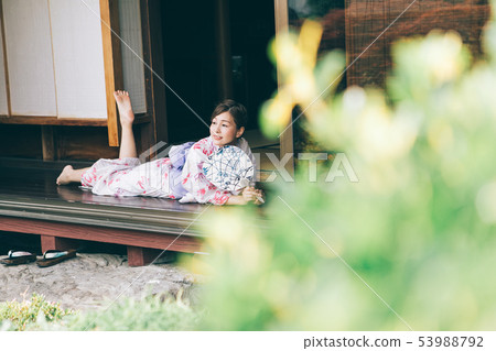 A woman in a yukata that cools on the veranda 53988792