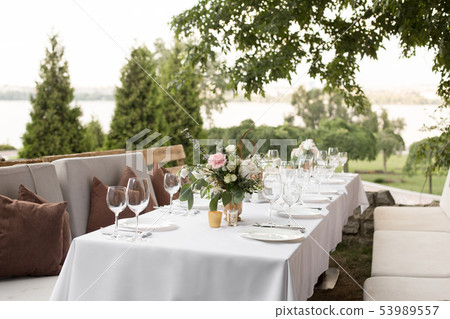 Wedding table setting decorated with fresh flowers Wedding table setting decorated with fresh flowers 53989557