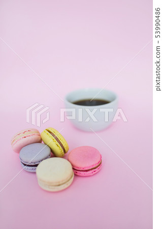 Macaroons and a cup of coffee on a pink background. 53990486