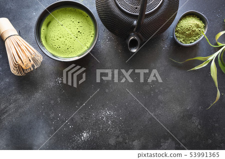 Ceremony green matcha tea and bamboo whisk on black table. Top view. Space for text. 53991365