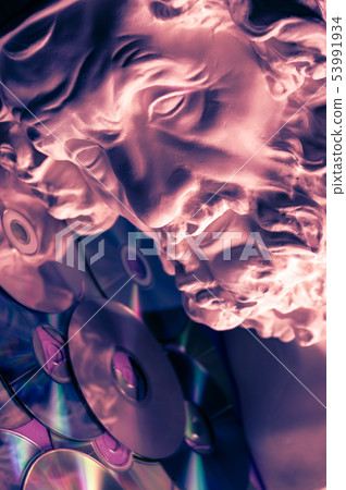 Antique statue of Homer head close up on a glitter CDs background. Concept of music, style, vintage. Antique statue of Homer head close up on a glitter CDs background. Concept of music, style, vintage. 53991934