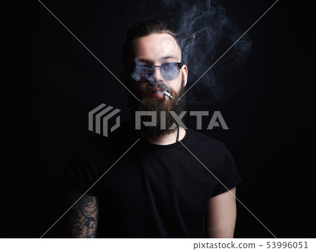handsome smoking man. Hipster tattoed boy with 53996051
