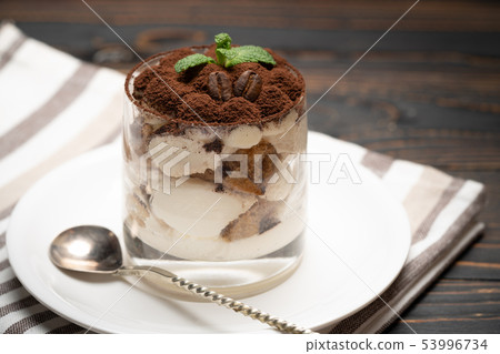 Classic tiramisu dessert in a glass on wooden background Classic tiramisu dessert in a glass on wooden background 53996734