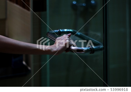 The woman's hand grabs handle door in the The woman's hand grabs handle door in the 53996918