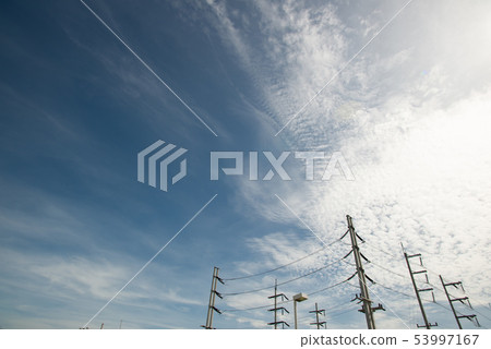 High voltage field with cloudy blue sky 53997167
