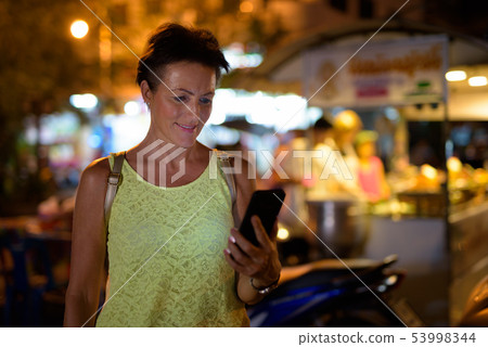 Mature beautiful Scandinavian tourist woman exploring Nakhon Pat 53998344