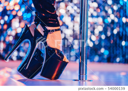 Legs in high sexy shoes near pylone. Striptease dancer moving on stage in strip Legs in high sexy shoes near pylone. Striptease dancer moving on stage in strip 54000139