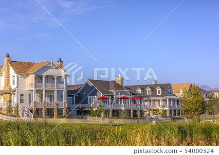 Homes with porch balcony and lawn under blue sky 54000324