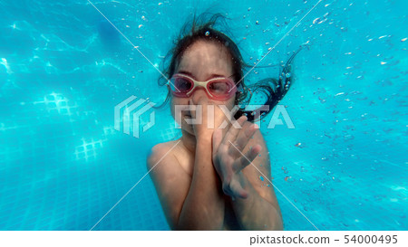 Little girl swimming underwater in pool 54000495