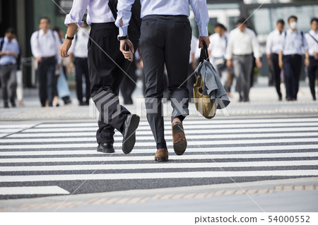 A back view of a businessman crossing a pedestrian crossing 54000552