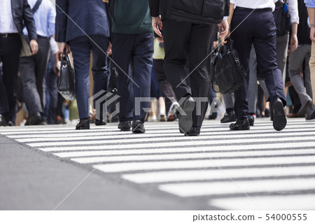 A back view of a businessman crossing a pedestrian crossing 54000555