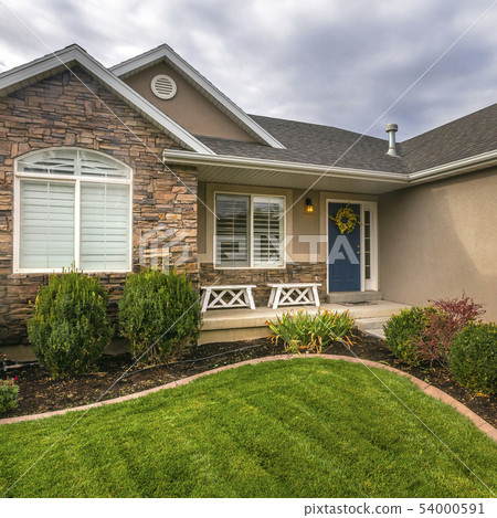 Home with yard porch and blue door against sky 54000591