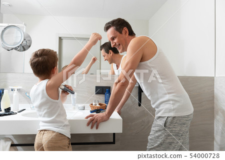 Little son using deodorant in the bathroom 54000728