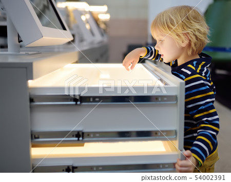 Little ?aucasian boy is looking an exposition in a Little ?aucasian boy is looking an exposition in a 54002391