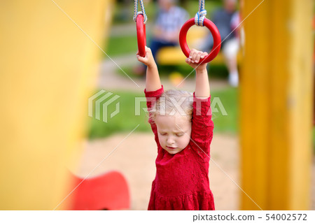 Little girl having fun on outdoor playground. 54002572