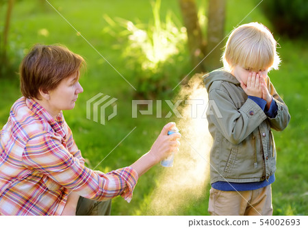 Woman spraying insect or mosquito repellents on Woman spraying insect or mosquito repellents on 54002693