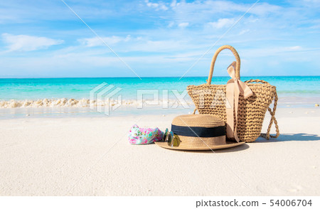 Hats and glasses placed on the beach and sea have  54006704