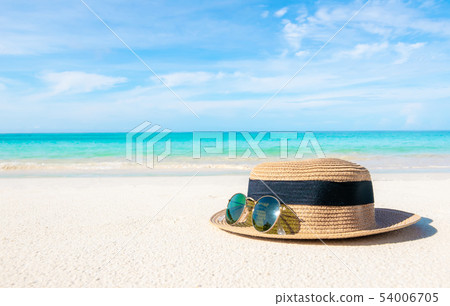 Hats and glasses placed on the beach and sea have  54006705