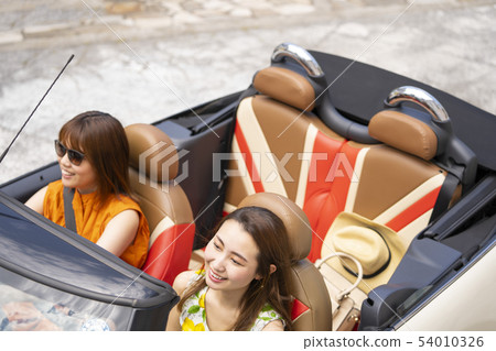 A lifestyle of two young women who enjoy sightseeing around cafes in an open car with stylish interiors A lifestyle of two young women who enjoy sightseeing around cafes in an open car with stylish interiors 54010326