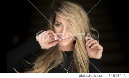 Fashion portrait of a blonde woman. touching lips by finger Fashion portrait of a blonde woman. touching lips by finger 54012441