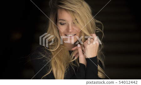 close-up portrait of shy smiling young blonde woman close-up portrait of shy smiling young blonde woman 54012442