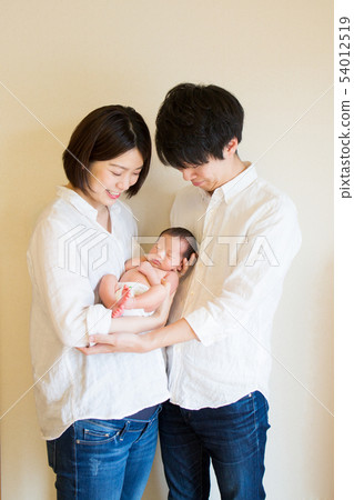 Dad and mom hug newborn baby and stare Dad and mom hug newborn baby and stare 54012519