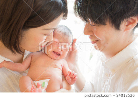 Dad and mom laughing at newborn baby 54012526