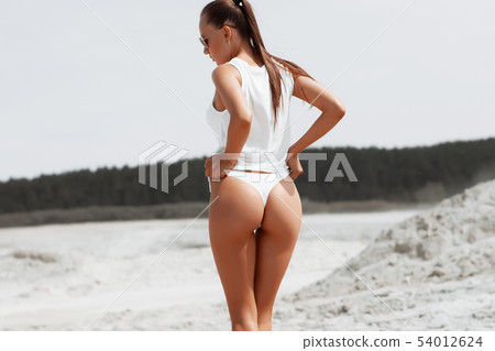 Girl with perfect figure in swimsuit on the beach Girl with perfect figure in swimsuit on the beach 54012624