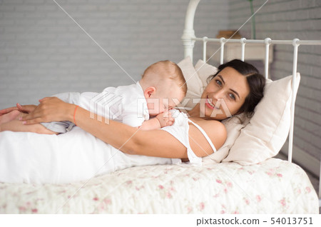 Sweet baby boy sleeping in bed with his mother 54013751