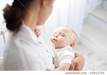 Baby sleeping on the mother's chest. Young mother Baby sleeping on the mother's chest. Young mother 54013754