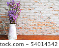 Purple bouquet in the white jar on wooden table 54014342