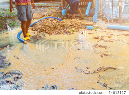 broken pipe in hole with water motion at roadside 54018117