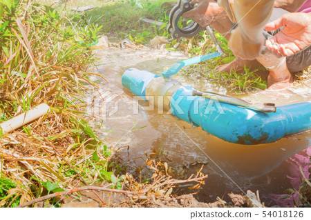 broken pipe in hole with water motion at roadside 54018126