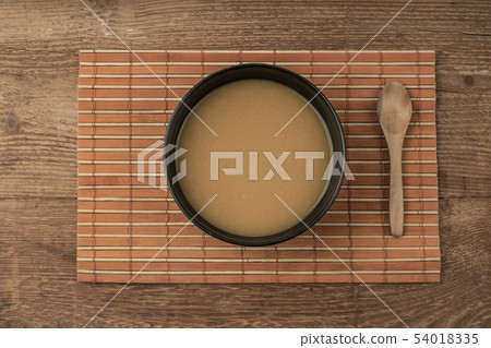 a bowl of soup on a wooden table 54018335