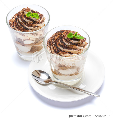 Classic tiramisu dessert in a glass on plate with spoon isolated on a white with clipping path 54020308
