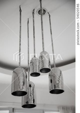 A group of mettalic hanging lights on white ceiling in loft designed appartment. 54020546
